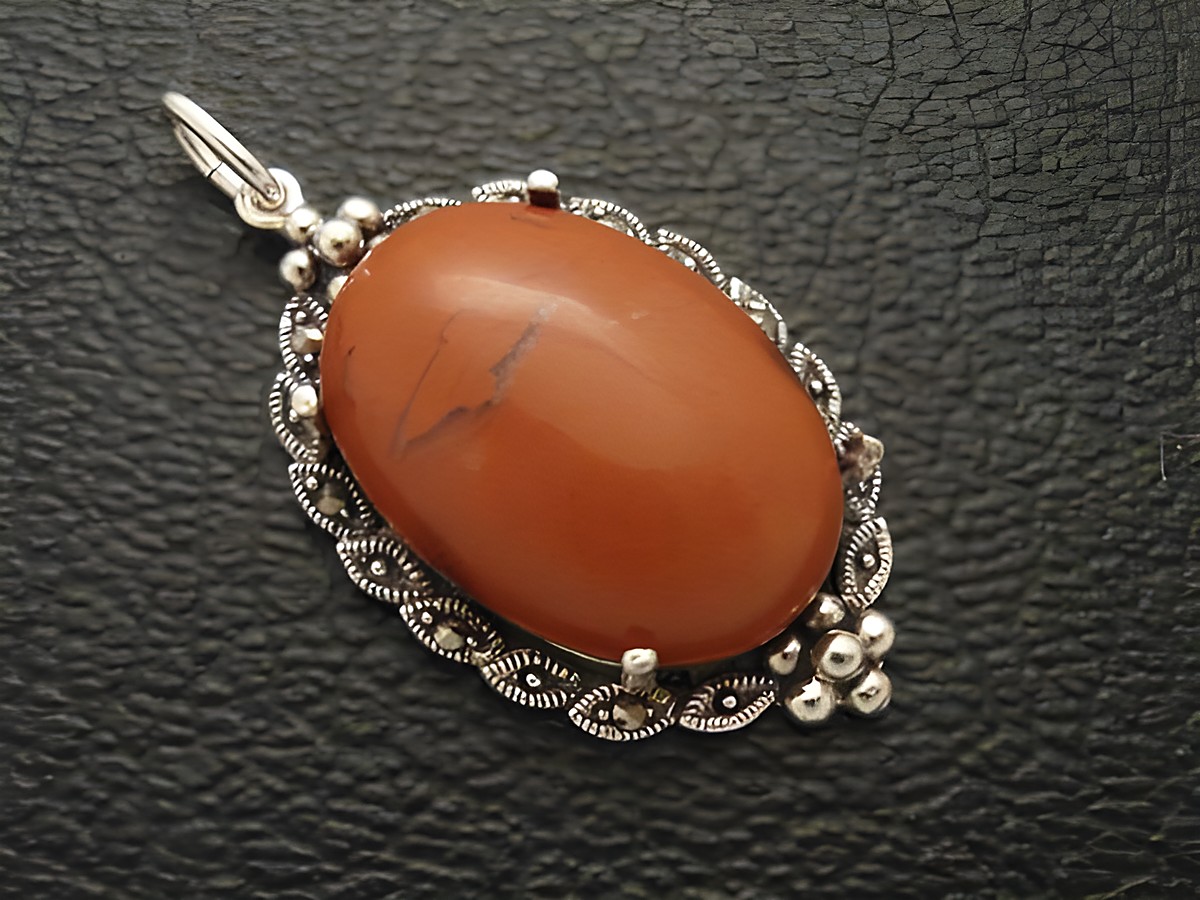 Cabochon Jaspis Silber Medaillon Anhänger gefertigt von Juwelier Harnisch, zeigt einen ovalen Jaspisstein in einem filigranen silbernen Rahmen mit dekorativen Elementen.