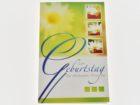 Geburtstagskarte mit weißen Blüten und bunten Akzenten, der Text zum Geburtstag und die besten Wünsche sind dekorativ gestaltet. Hersteller ist Juwelier Harnisch.