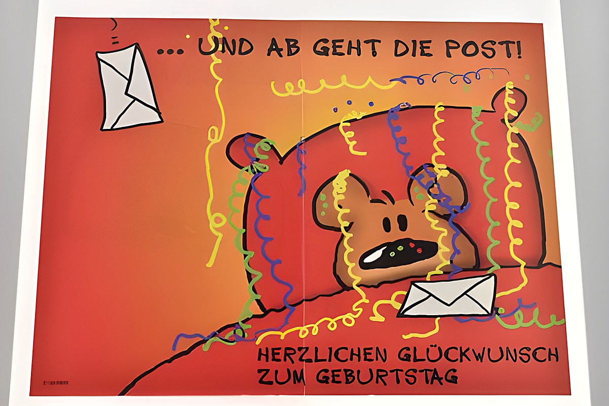 Eine bunte Geburtstagskarte mit einem fröhlichen Bärchen, das auf einem Sofa sitzt. Umgeben von Luftschlangen und Briefumschlägen. Der Text lautet Herzlichen Glückwunsch zum Geburtstag. Hersteller Juwelier Harnisch. – Ansicht 2
