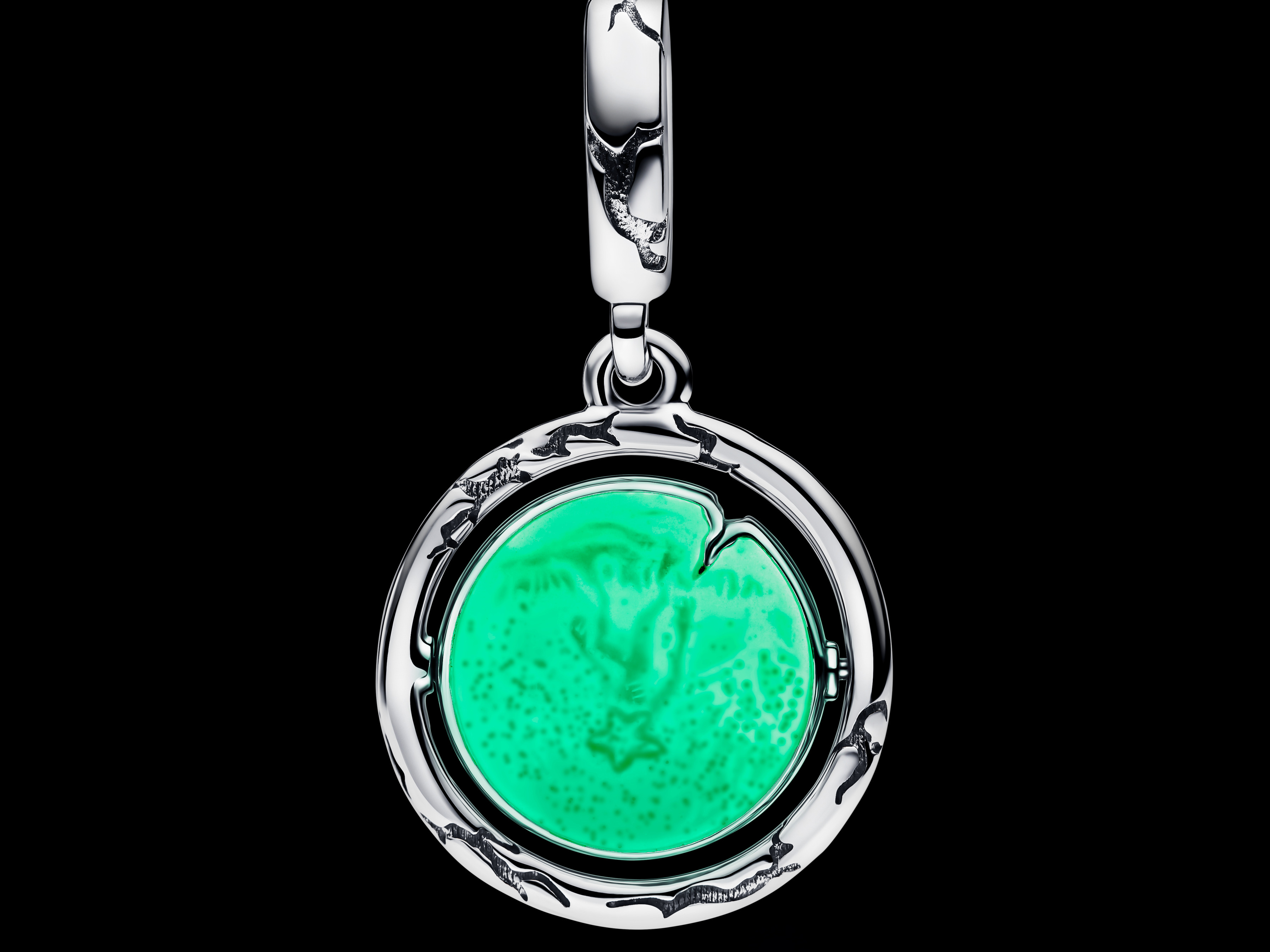 Silberner Pandora Charm 793563C01 aus der Stranger Things Kollektion, leuchtet in der Dunkelheit, zeigt eine grüne, leuchtende Oberfläche in einem detaillierten Anhängerdesign.
