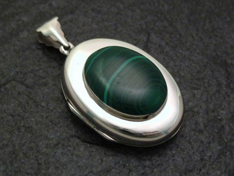 Ovales Malachit Medaillon aus 925 Sterling Silber, hergestellt von Juwelier Harnisch, mit schöner grün-brauner Musterung und glänzender Oberfläche. Ideal als elegantes Schmuckstück.