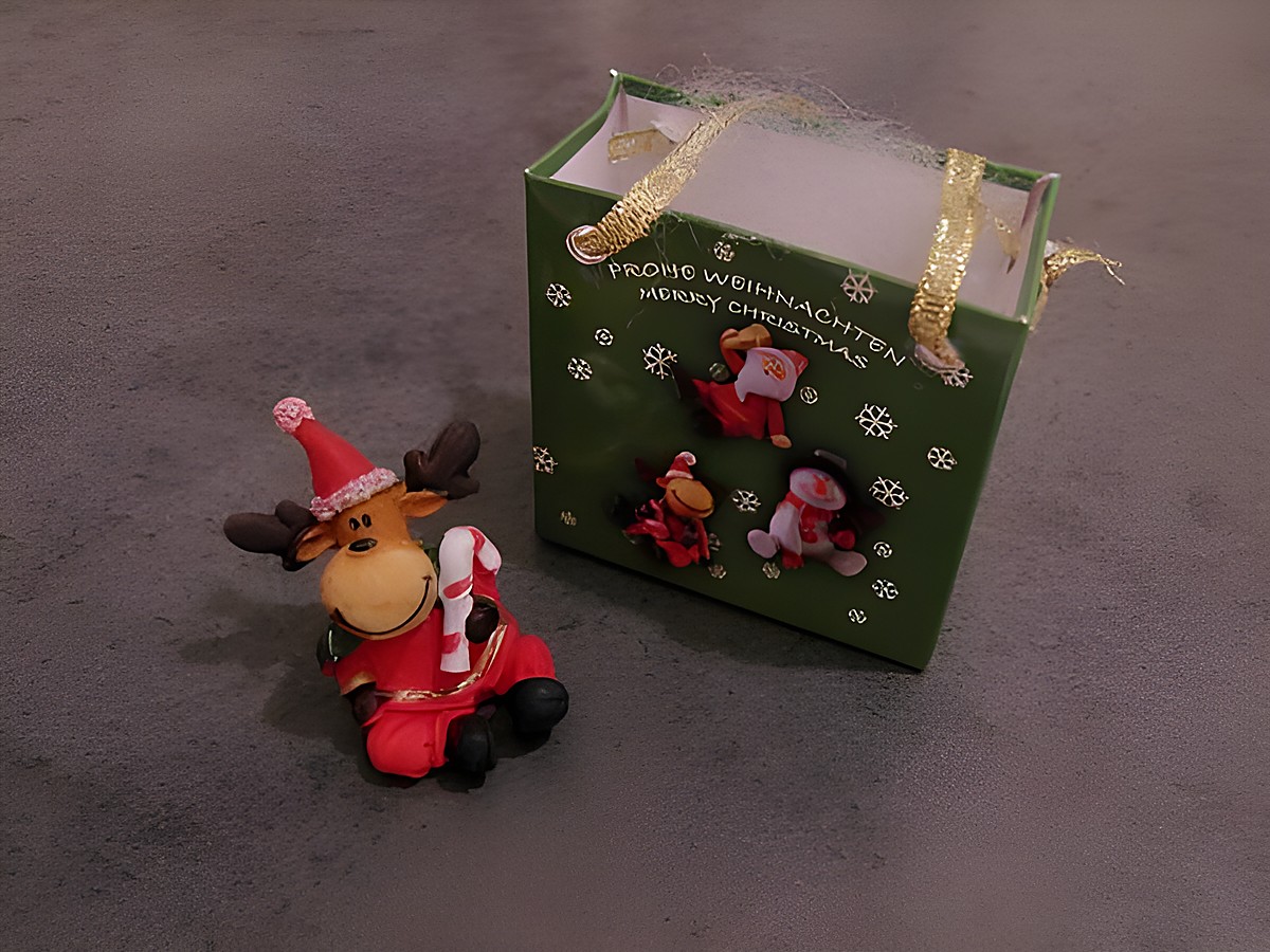 Elch Rentier mit Geschenktasche sitzend mit Zuckerstange, Hersteller Juwelier Harnisch, Weihnachten.