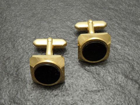 Manschettenknöpfe vergoldet in Onyx-Look, goldfarben von Juwelier Harnisch, quadratisches Design mit schwarzem Innenleben, elegantes Accessoire für stilvolle Outfits.