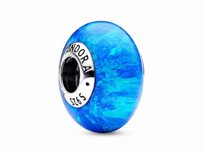 Der Pandora Schillernde Tiefblaue Ozean Charm aus Sterling Silber zeigt eine runde, tiefblaue Glasoberfläche, die an das Meer erinnert, und ist perfekt für Reise- und Urlaubsthemen.