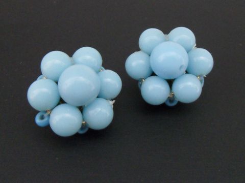 Ohrclip in hellblau mit blumigem Design und goldfarbenen Akzenten, mit synthetischen Zuchtperlen, hergestellt vom Juwelier Harnisch. Ideal für jeden Anlass.