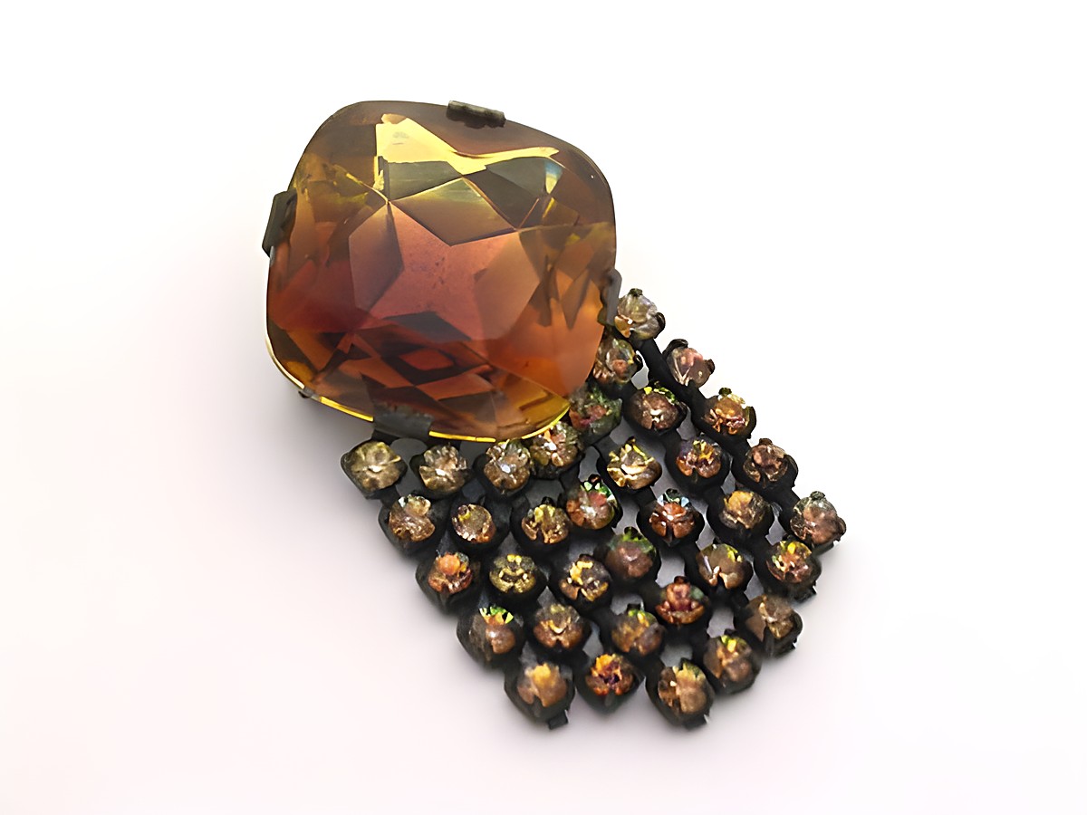 Strass Brosche länglich in Braun und Gelb, gefasst, neu vom Hersteller Juwelier Harnisch, mit einem großen facettierten Stein und einem Blumenmuster aus kleinen Strasssteinen.