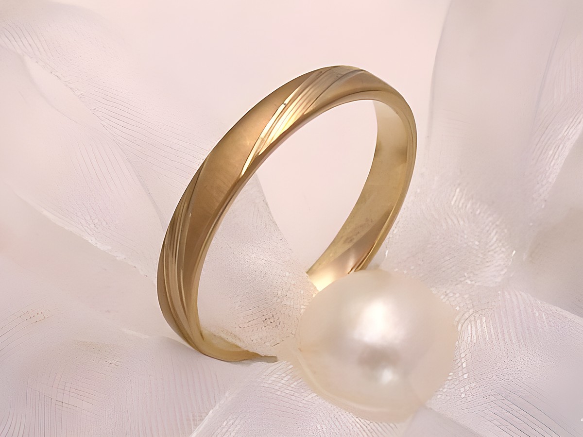 Trauring Ehering CLASSY aus Gold 333 in Größe 56/17,8 von Juwelier Harnisch, elegant mit feiner Struktur, gelegt auf einem zarten Stoff mit einer Perle.