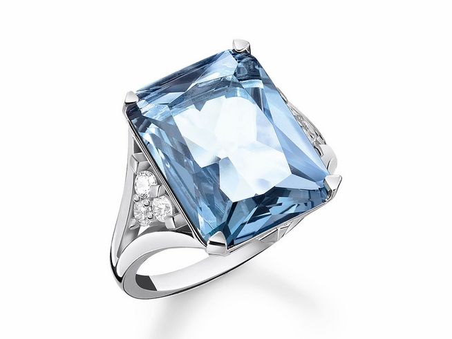 Der Ring aus Silber mit synth. Spinell und Zirkonia in blau hat einen oktagonalen, facettierten Stein und ist mit funkelnden Details verziert, Größe 56.