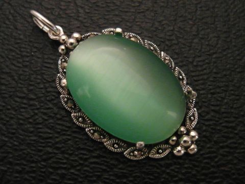 30714-0 Cabochon Katzenauge hellgrün in einem filigranen Silber Medaillon Anhänger, hergestellt von Juwelier Harnisch, ideal für elegante Schmuckliebhaber.