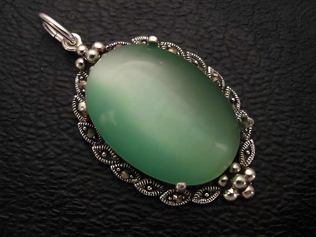 Cabochon Katzenauge hellgrün in einem filigranen Silber Medaillon Anhänger, hergestellt von Juwelier Harnisch, ideal für elegante Schmuckliebhaber.