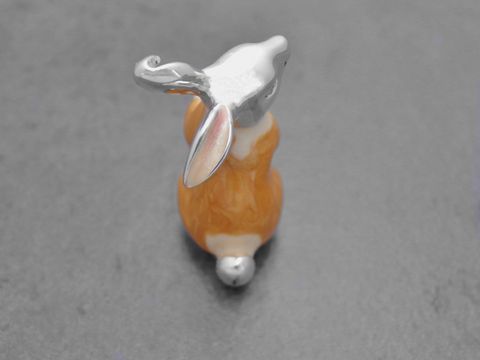 Hase aus Echtsilber, stehend, mit hellbraun-braun Emaille. Die Figur hat eine glänzende silberne Oberfläche und ist 34 mm groß. Hersteller: Juwelier Harnisch.