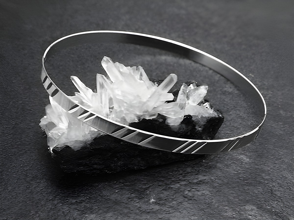 Silber Armreifen Diamantschliff aus den 70er Jahren mit einer Breite von 4,2 mm und einer Länge von 20 cm, Hersteller Juwelier Harnisch, elegant auf Kristallen präsentiert.