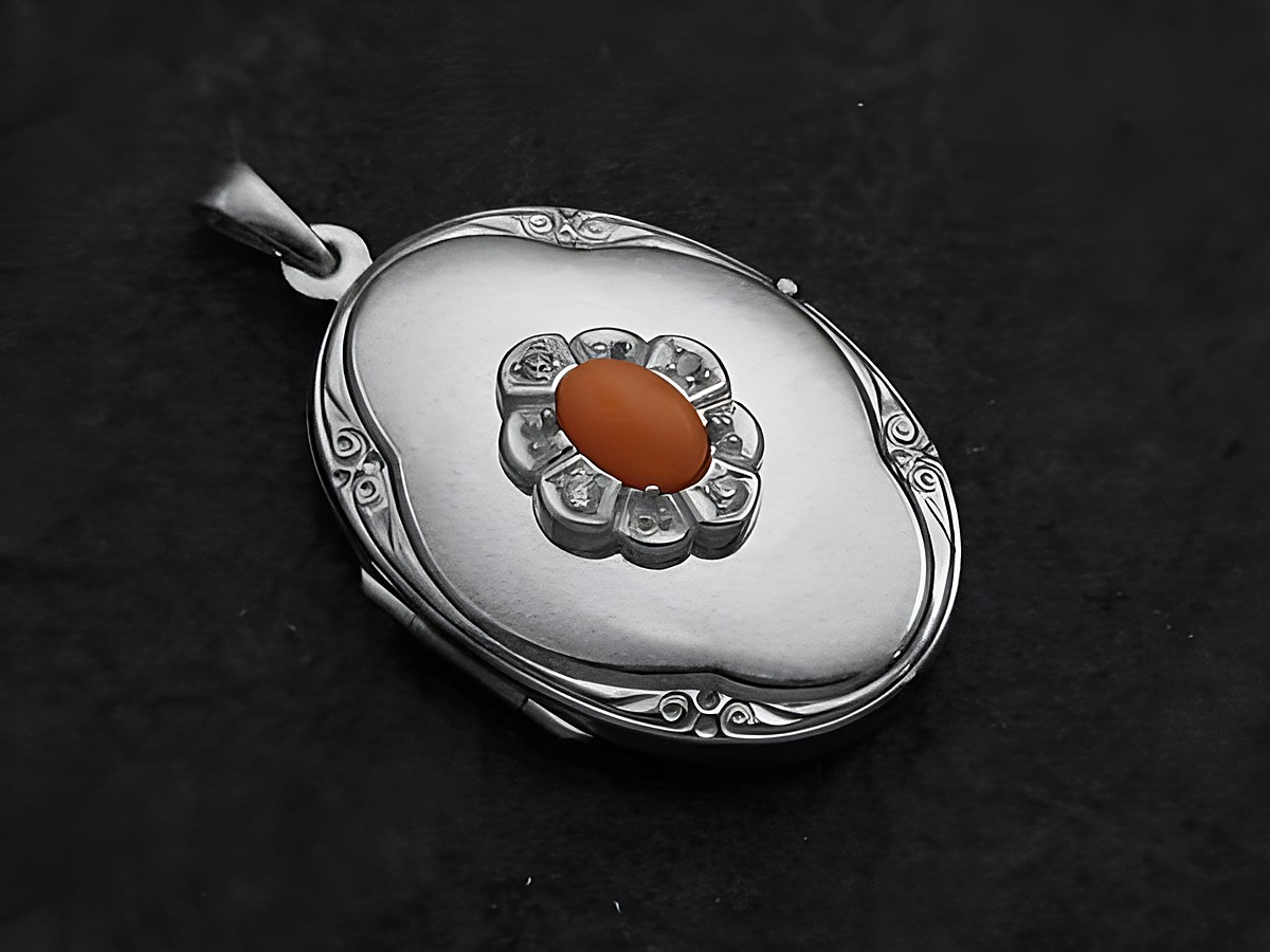 Medaillon aus Weißgold 585 mit koralle rosa Cabochon und einem floralen Design in der Mitte, hergestellt von Juwelier Harnisch, elegant und zeitlos.