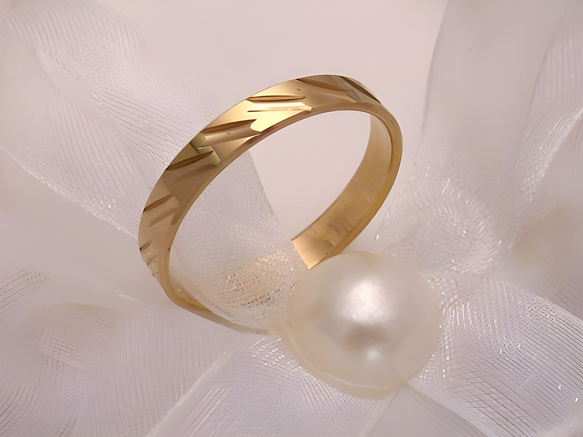 Trauring Ehering NOBLE aus Gold 333 in Größe 53/16,9, Hersteller Juwelier Harnisch, bis Größe 54/17,2, geprägtes Muster und elegante Ausstrahlung, auf einem weißen Untergrund mit einer Perle.