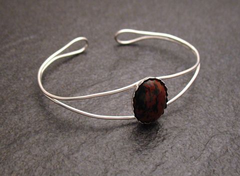 Mahagoni Obsidian Armreifen in 18 cm Umfang aus Sterling Silber mit ovalem, rot-schwarz gemustertem Stein in der Mitte, elegant und zeitlos gestaltet. Ideal für stilvolle Auftritte.