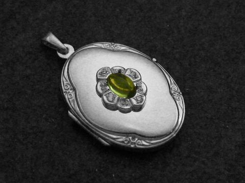 Peridot Medaillon Cabochon aus Sterling Silber rhodiniert, mit einem zentralen grünen Stein und dekorativen Details, gefertigt vom Juwelier Harnisch. Ideal als elegantes Schmuckstück.