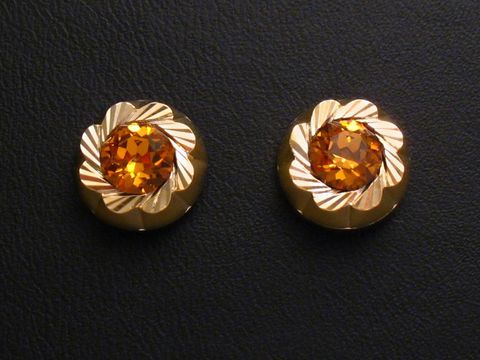 Ohrringe in gold mit orange facettierten Steinen, vom Juwelier Harnisch, verziert mit weiteren Steinen, blumenähnliches Design, eleganter Schmuck für besondere Anlässe.