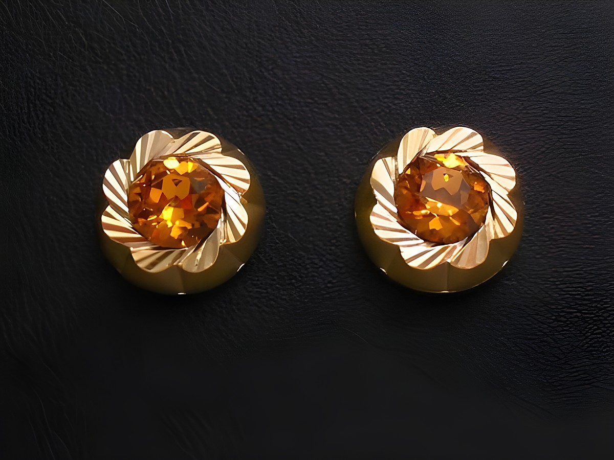Ohrringe in gold mit orange facettierten Steinen, vom Juwelier Harnisch, verziert mit weiteren Steinen, blumenähnliches Design, eleganter Schmuck für besondere Anlässe.