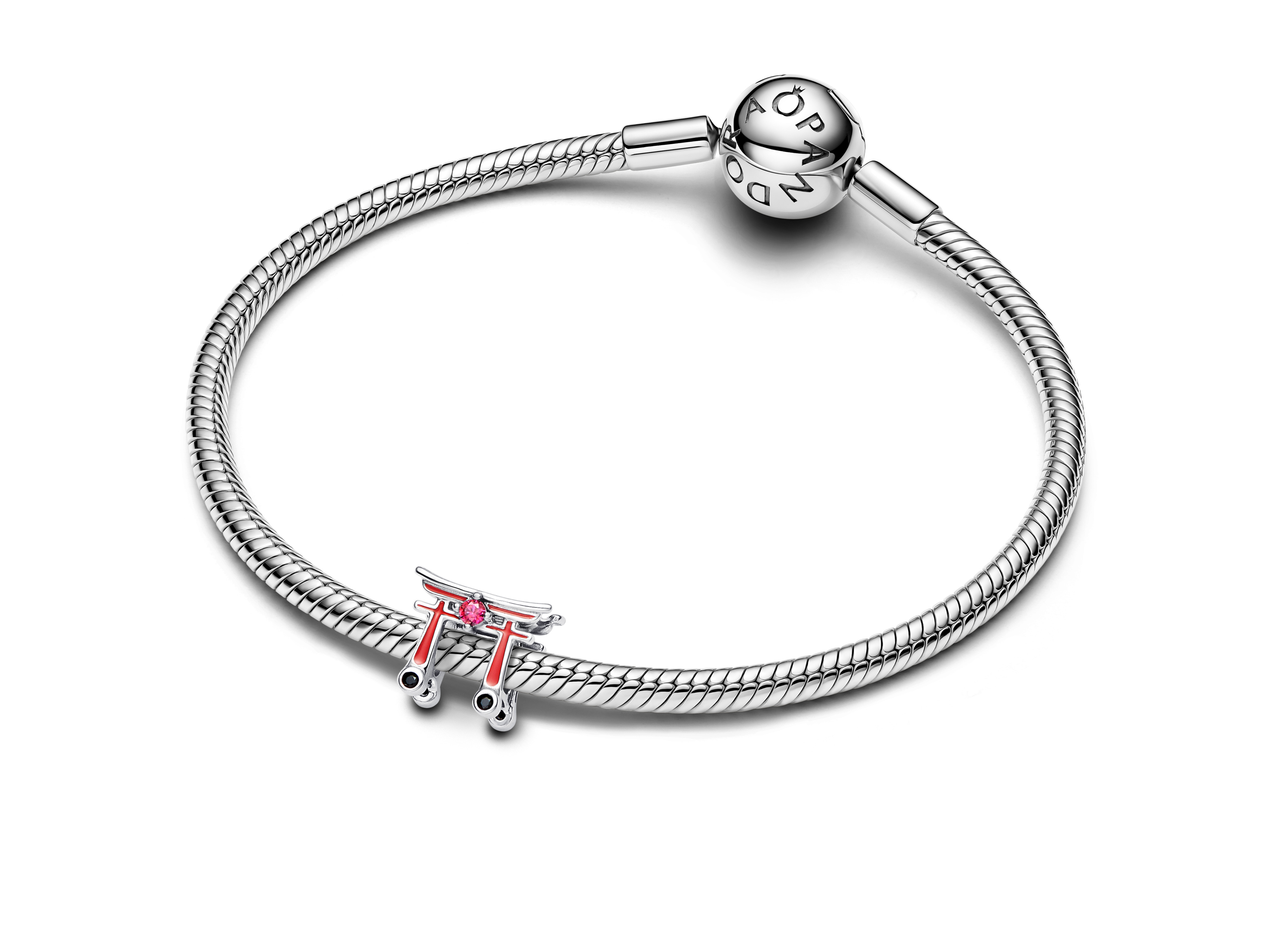 Das Bild zeigt ein Armband aus Sterling Silber von Pandora mit einem Torii Tor Charm, das rot und silberfarben ist und einen funkelnden Stein enthält.