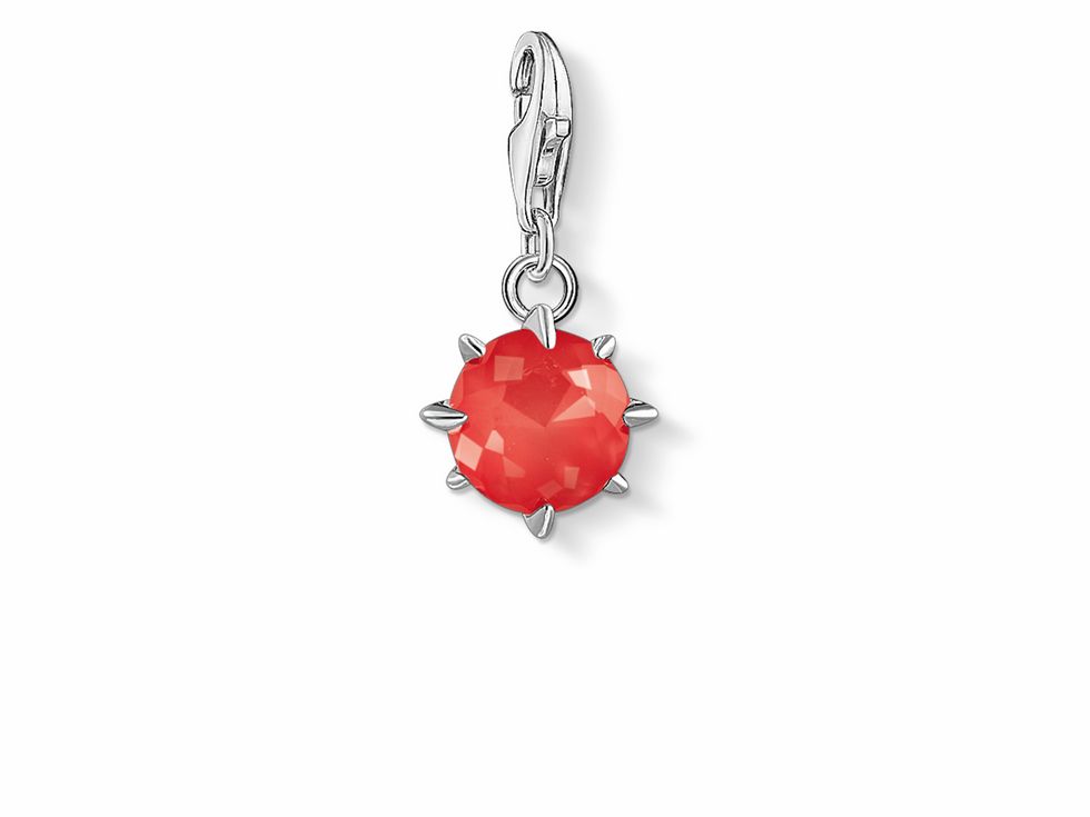 Charm-Anhänger von Thomas Sabo in Silber mit rotem Geburtsstein für den Monat Juli, facettiert und von Spikes umgeben, ideal für persönliche Schmuckkollektionen.
