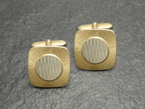 Manschettenknöpfe vergoldet im klassischen 70er Design von Juwelier Harnisch, goldfarben mit strukturiertem quadratischen Muster und rundem Zentrum. Ideal für elegante Anlässe.