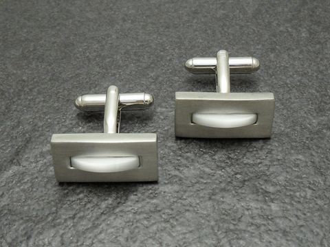 Silberfarbene Manschettenknöpfe mit weißer Einlage, Hersteller Juwelier Harnisch, elegant und zeitlos gestaltet, ideal für besondere Anlässe und formelle Kleidung.