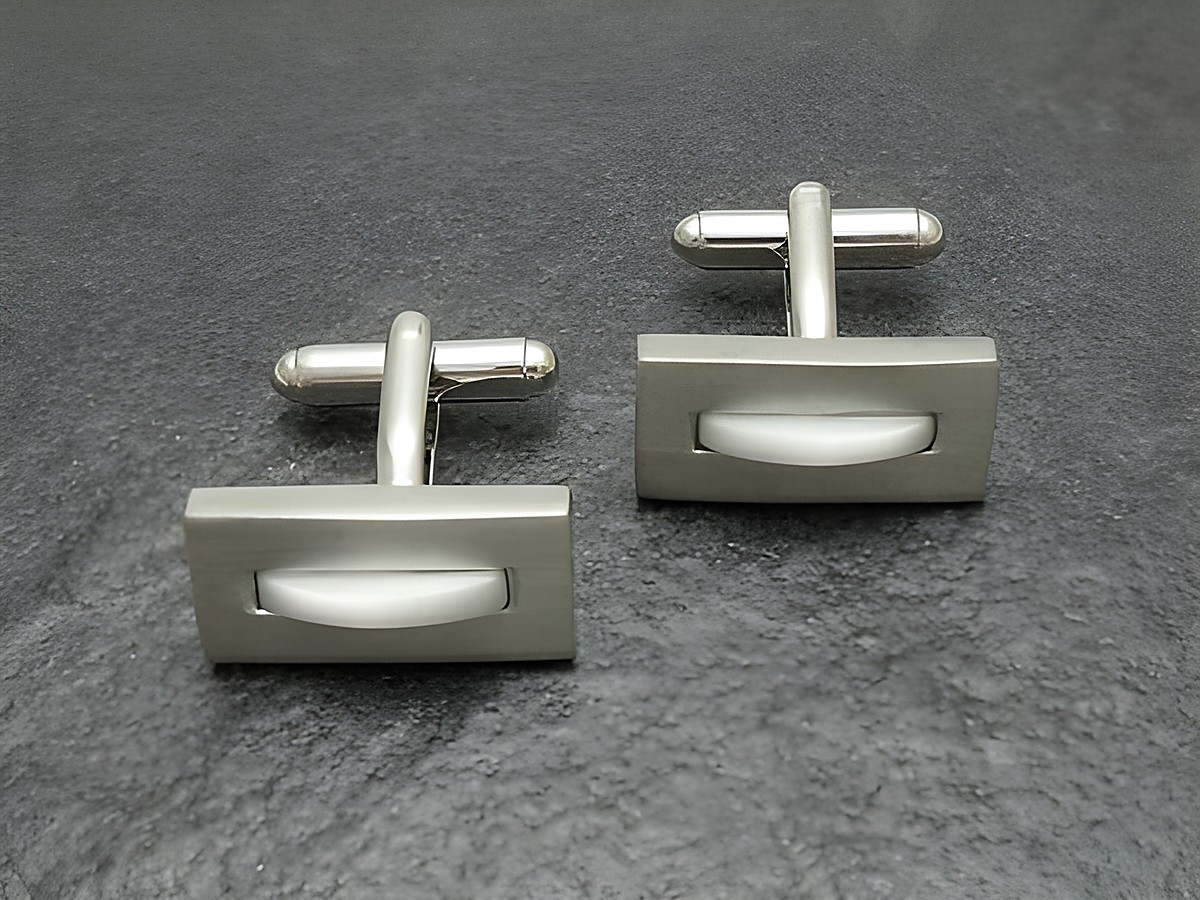 Silberfarbene Manschettenknöpfe mit weißer Einlage, Hersteller Juwelier Harnisch, elegant und zeitlos gestaltet, ideal für besondere Anlässe und formelle Kleidung.
