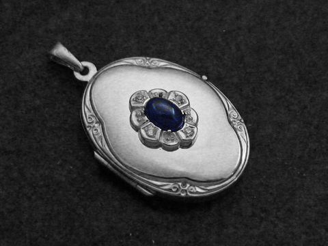 Medaillon aus Sterling Silber mit einem blauen Saphir Cabochon in der Mitte, umgeben von Brillanten, vom Juwelier Harnisch. Elegantes Schmuckstück mit feiner Verarbeitung.