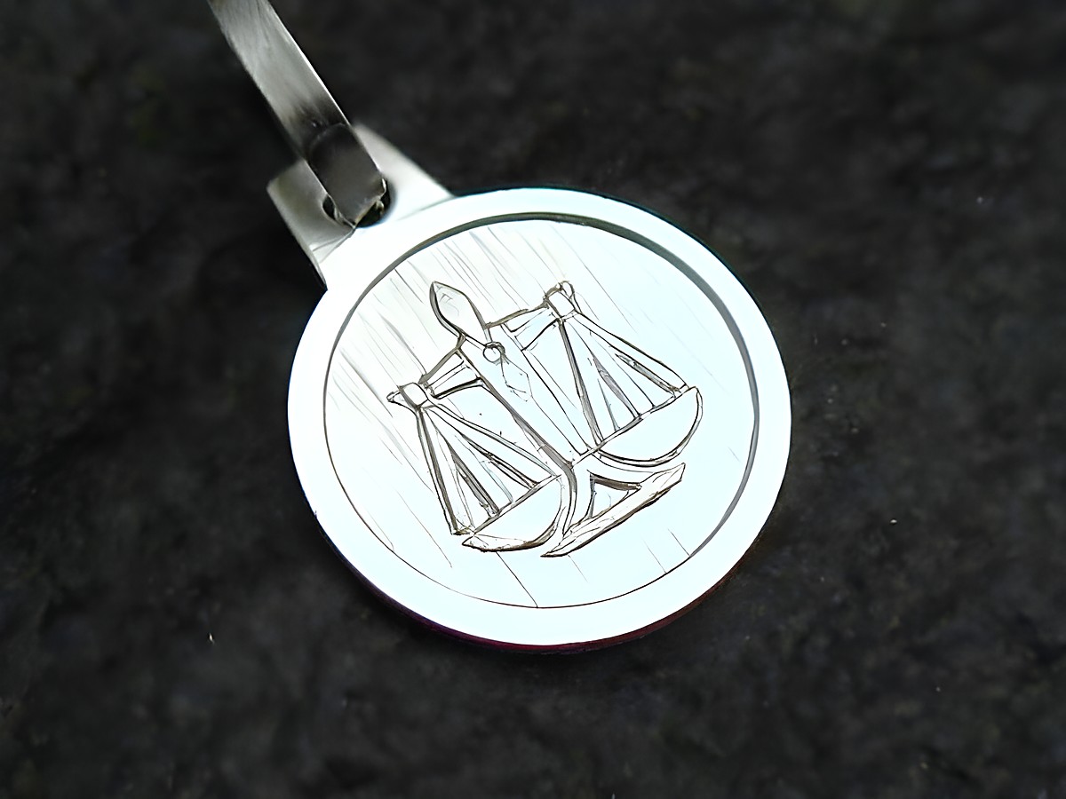 Sternzeichen Anhänger Waage aus Sterling Silber, hergestellt von Juwelier Harnisch, zeigt eine feine Gravur mit Waagschalen auf einer runden Platte.