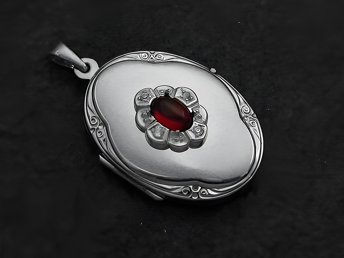 Granat rot-braun Medaillon Cabochon in Weißgold 333 mit Brillanten, hergestellt von Juwelier Harnisch. Elegante Form mit detaillierter Verzierung und zentralem Edelstein.