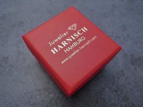 Viereckige rote Geschenkschachtel von Juwelier Harnisch mit schwarzem Deckel, Maße 45 x 40 x 30 mm, ideal für die Präsentation von Schmuckstücken.