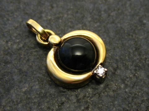 Onyx mit Diamant - Gold Anhänger in runder Form, zentraler schwarzer Onyxstein, umgeben von glänzendem Gold und einem funkelnden Diamanten, Hersteller Juwelier Harnisch.