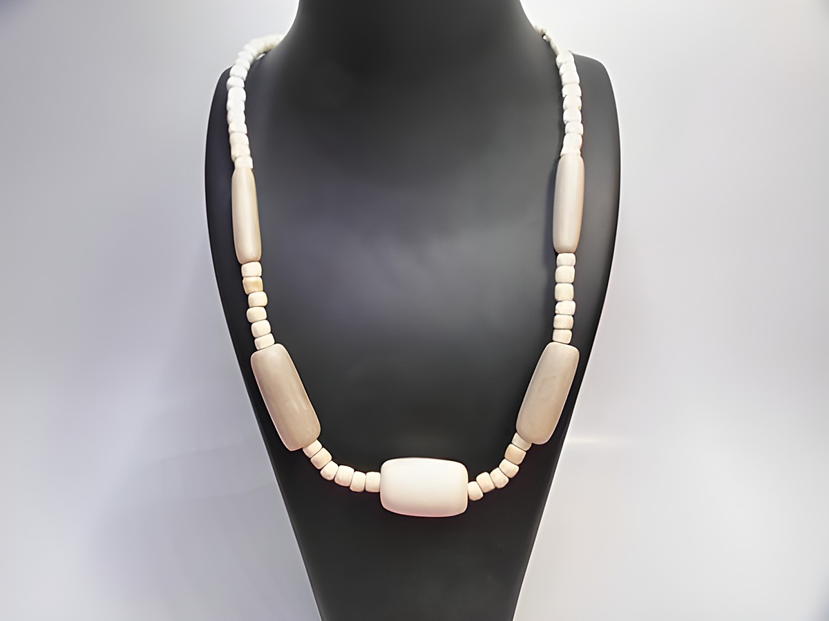 Holzkette aus Zylinderformen mit einer Länge von 60 cm in naturbraun. Die Kette hat einen schlichten, eleganten Look und wurde von Juwelier Harnisch gefertigt.