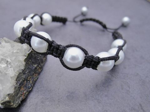 Shamballah Armband in Weiß mit synthetischen Zuchtperlen und einem schwarzen Makramee-Band, verstellbar von 18 bis 28 cm, hergestellt von Juwelier Harnisch.