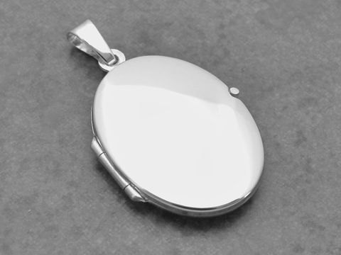 Ein ovales, klassisch elegantes Medaillon aus Weißgold 333, Hersteller Juwelier Harnisch, mit glatter Oberfläche und hochwertiger Verarbeitung ideal für persönliche Erinnerungen.