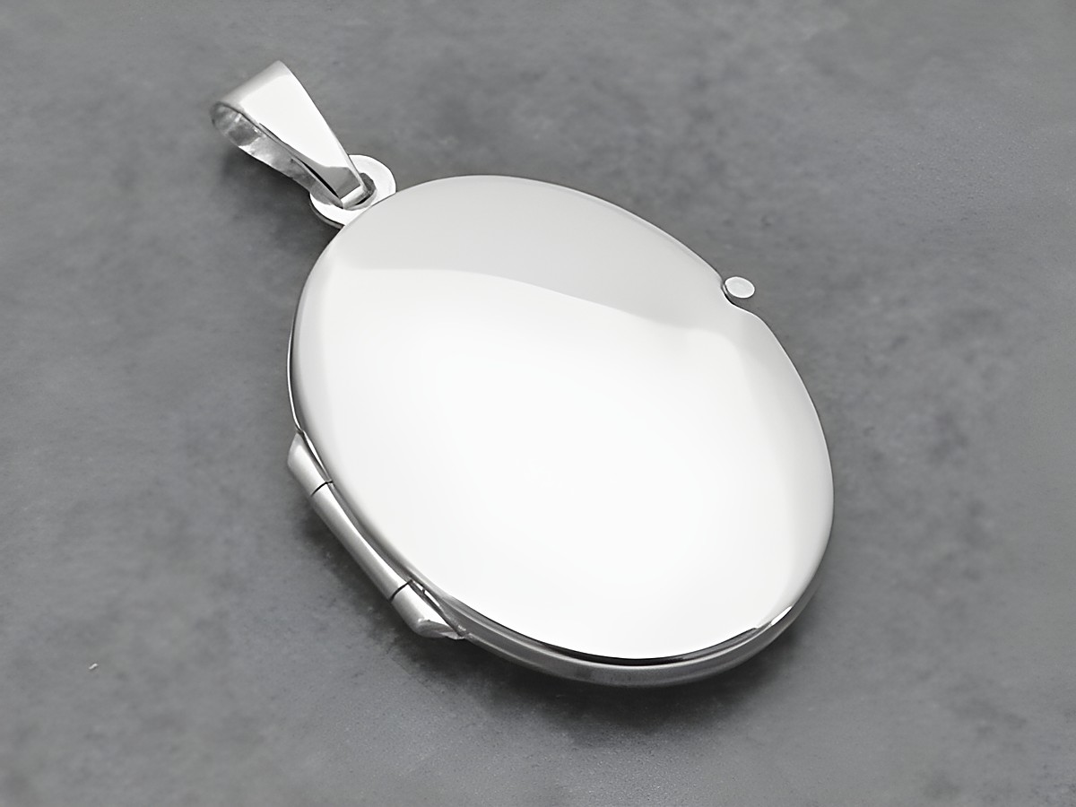 Ein ovales, klassisch elegantes Medaillon aus Weißgold 333, Hersteller Juwelier Harnisch, mit glatter Oberfläche und hochwertiger Verarbeitung ideal für persönliche Erinnerungen.