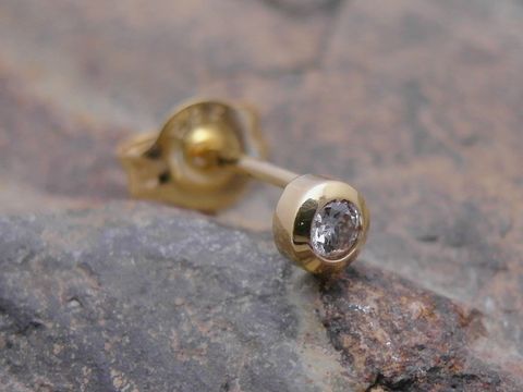 Ein Ohrstecker unisex aus Gold 585, filigran gestaltet und mit einem Brillant besetzt. Hersteller ist Juwelier Harnisch. Einzelstück, ideal für elegante Akzente.