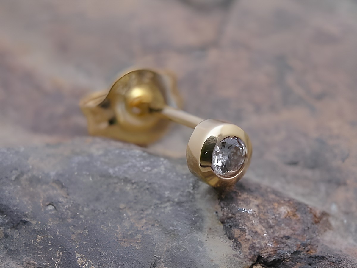 Ein Ohrstecker unisex aus Gold 585, filigran gestaltet und mit einem Brillant besetzt. Hersteller ist Juwelier Harnisch. Einzelstück, ideal für elegante Akzente.