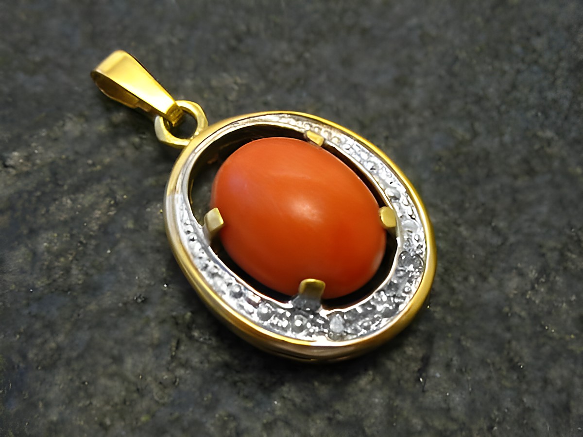 Goldanhänger in Bicolor mit einem ovalen roten Korallenstein, umgeben von funkelnden Diamanten, hergestellt von Juwelier Harnisch, ideal für stilvolle Akzente.