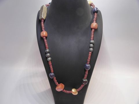 Holzkette Multiform 37 mm bunt 90 cm Holz Schmuck von Juwelier Harnisch mit verschiedenen bunten Perlen und platzierten Akzenten, elegant präsentiert auf einem schwarzen Ständer.