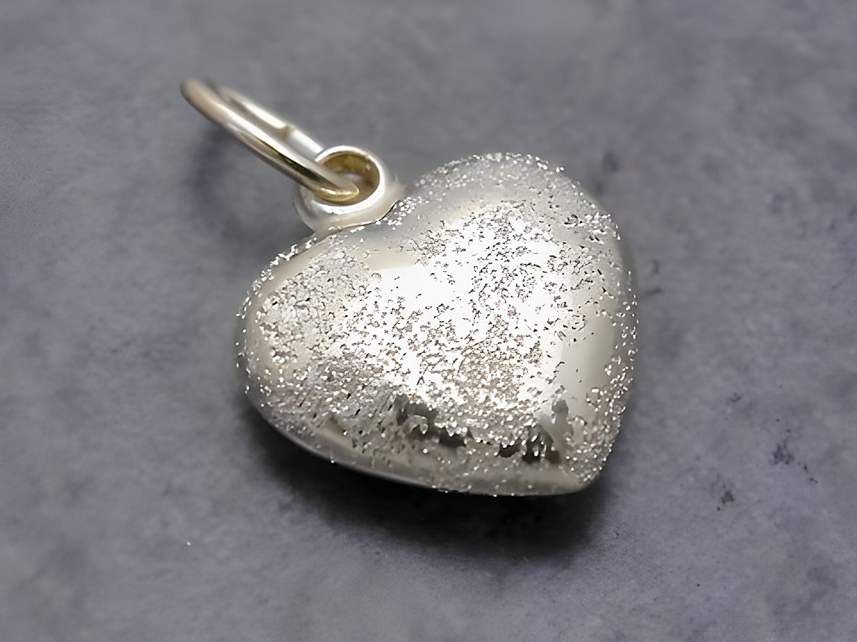 Herz Anhänger aus Gold, funkelnd und mattiert, mit einer Größe von 9,6 mm, plastisch gestaltet und vom Hersteller Juwelier Harnisch gefertigt.