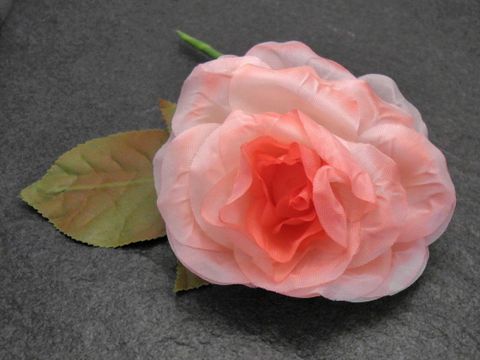 Haarschmuck aus opulentem rosa Textil in Form einer Blume mit Blatt, ideal für besondere Anlässe, Hersteller Juwelier Harnisch, verleiht jeder Frisur einen eleganten Akzent.