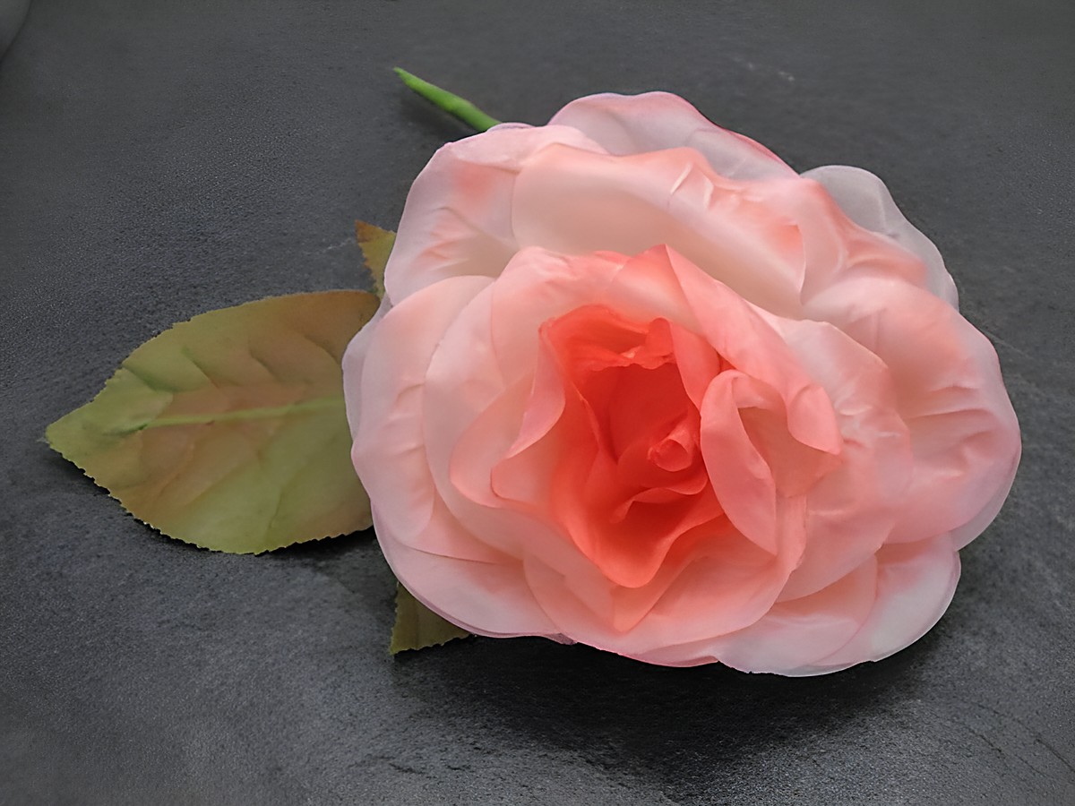 Haarschmuck aus opulentem rosa Textil in Form einer Blume mit Blatt, ideal für besondere Anlässe, Hersteller Juwelier Harnisch, verleiht jeder Frisur einen eleganten Akzent.