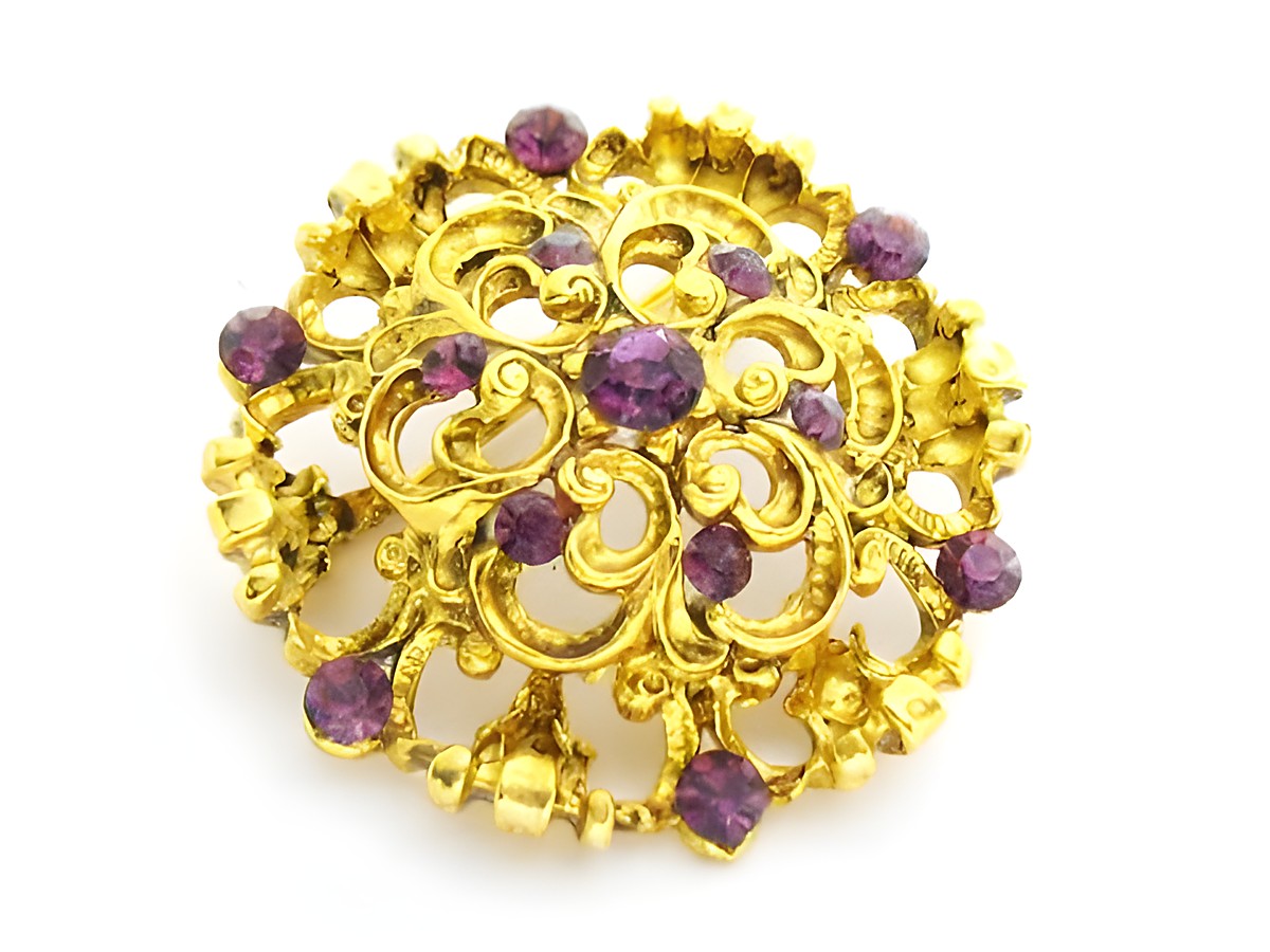 Brosche im Sexy City Look mit lila Strass, rundes Design, goldfarbene Details, Hersteller Juwelier Harnisch, ideal für elegante Akzente und besondere Anlässe.