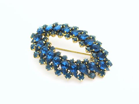 Blaue Strass Brosche im sexy City Look, oval geformt, hergestellt von Juwelier Harnisch, funkelt in verschiedenen Blautönen und verleiht jedem Outfit Eleganz und Stil.