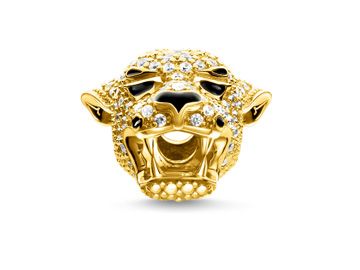 Ein goldfarbener Karma Bead von Thomas Sabo in Form eines Löwenkopfes, besetzt mit funkelnden Steinen und detaillierter Gestaltung, der einen majestätischen Eindruck vermittelt.