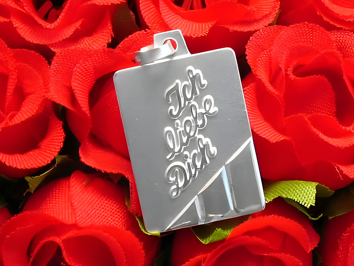 Silberne Gravurplatte in Rechteckform mit dem eingravierten Text Ich Liebe Dich, umgeben von roten Rosen, ideal als Geschenk für besondere Anlässe. Hersteller: Juwelier Harnisch.