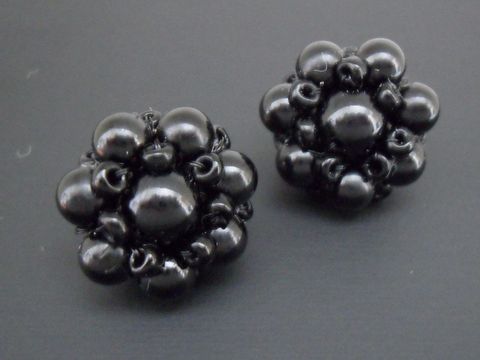Ohrclip in Schwarz mit blumigem Design und silberfarbenen Elementen, verziert mit synthetischen Zuchtperlen, Hersteller Juwelier Harnisch. Ideal für elegante Anlässe.