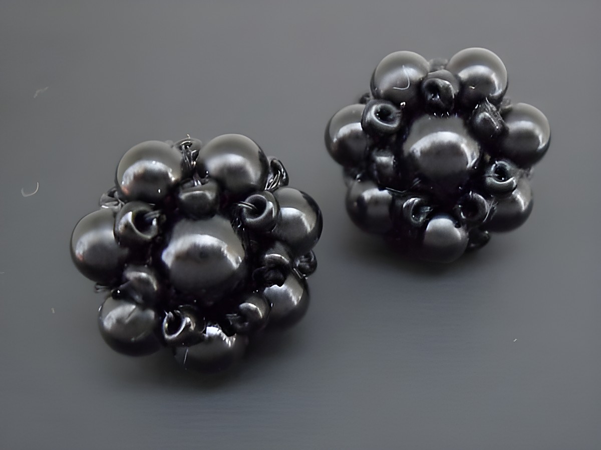 Ohrclip in Schwarz mit blumigem Design und silberfarbenen Elementen, verziert mit synthetischen Zuchtperlen, Hersteller Juwelier Harnisch. Ideal für elegante Anlässe.