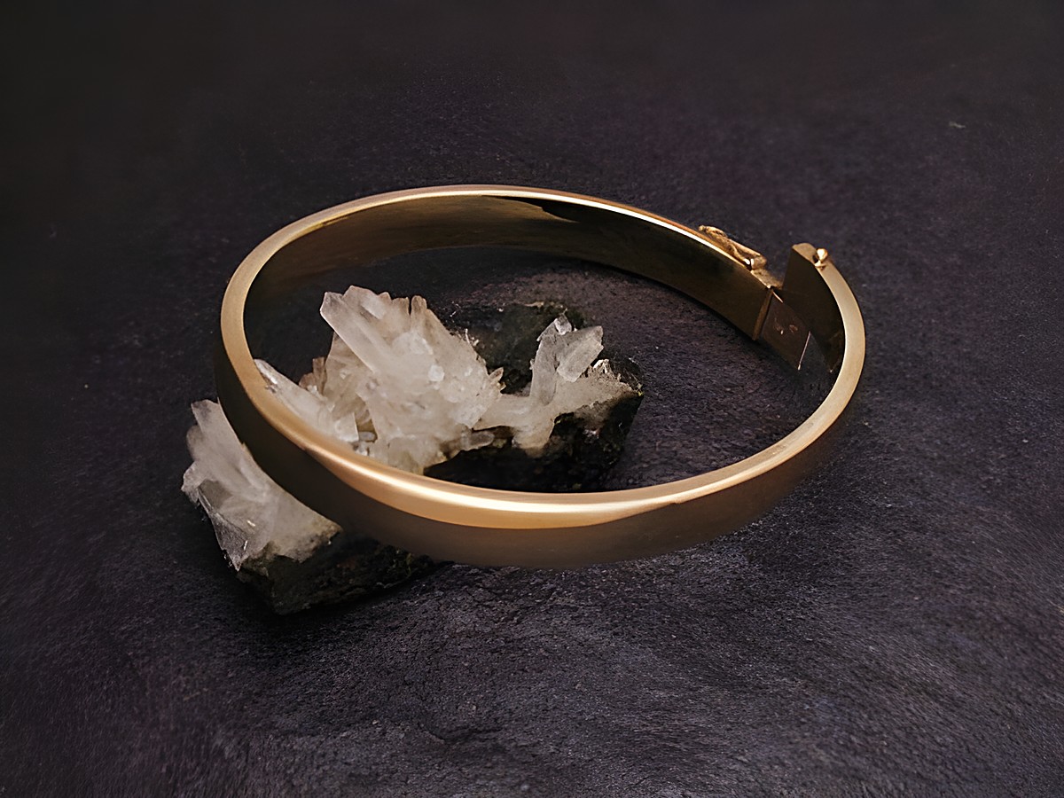 Echter goldener Armreifen mit einer Breite von 10,3 mm und einer Länge von 21 cm, hergestellt von Juwelier Harnisch, elegant auf schwarzem Untergrund präsentiert.